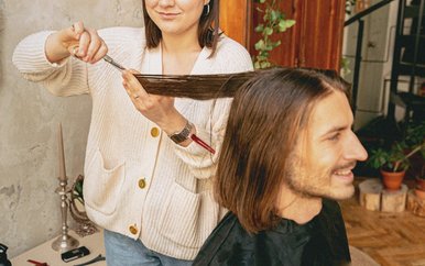 Hair stylist cutting a client's long hair in her salon
