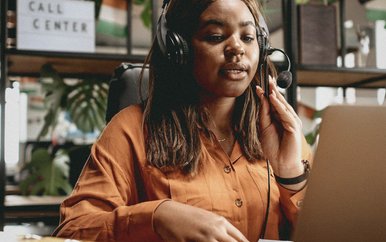 Sales rep in a headset on a call at her laptop