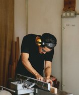 Young maker cutting a wooden board at a workbench