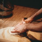 Baker kneading dough on a wooden table