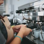 Barista pulling an espresso shot at a café machine