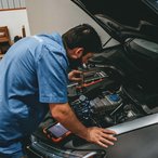 Mechanic checking a car engine under the open hood