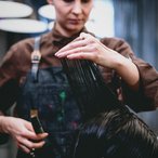 Stylist cutting a client's wet hair in a salon