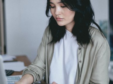 Woman working on a laptop at her desk, focused