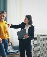 Real estate agent talking with a young couple inside a home