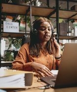 Sales rep in a headset on a call at her laptop