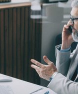 Senior salesperson on a phone call at his office desk